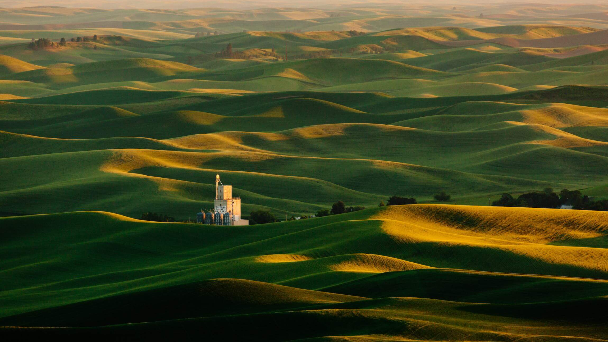 break-down-organizational-silos large green field with hills and several silos in the distance